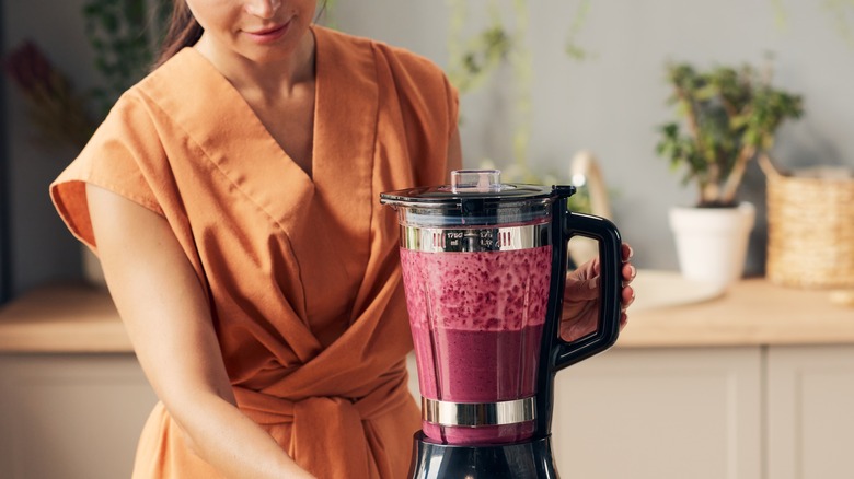 a woman blending a smoothie 