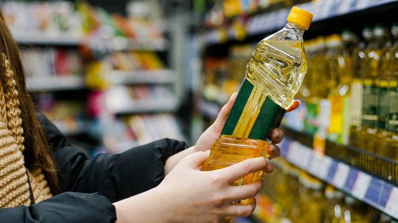 Someone holds a bottle of sunflower oil