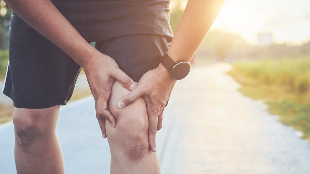 Man in pain holding injured leg