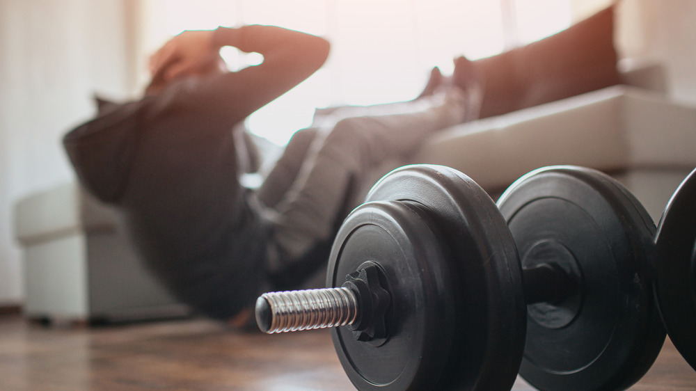 Man doing sit-ups below couch