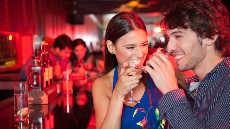 man and a woman at a bar drinking alcohol
