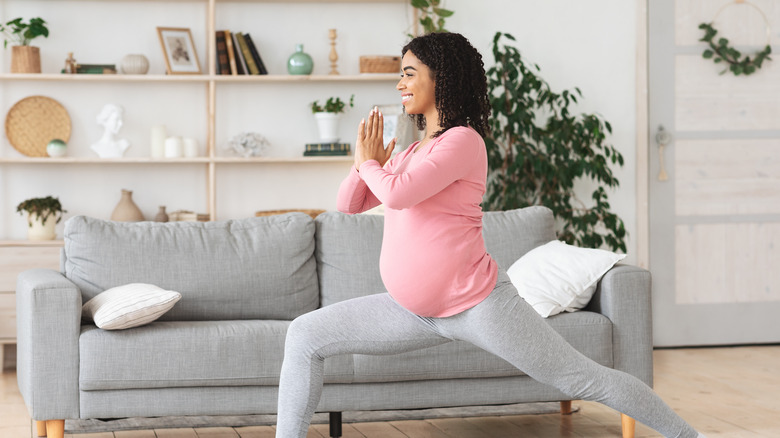 Pregnant woman in yoga pose at home