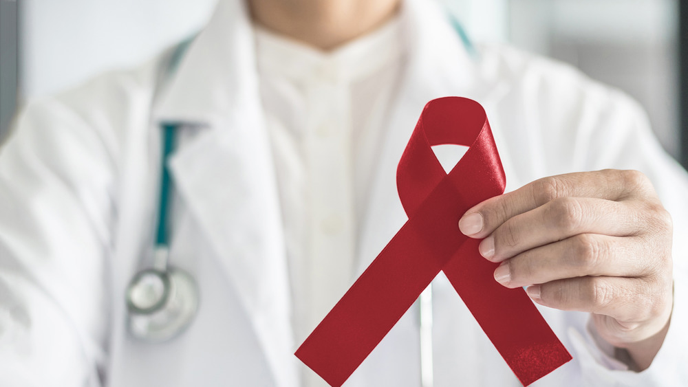 Doctor holding a red ribbon