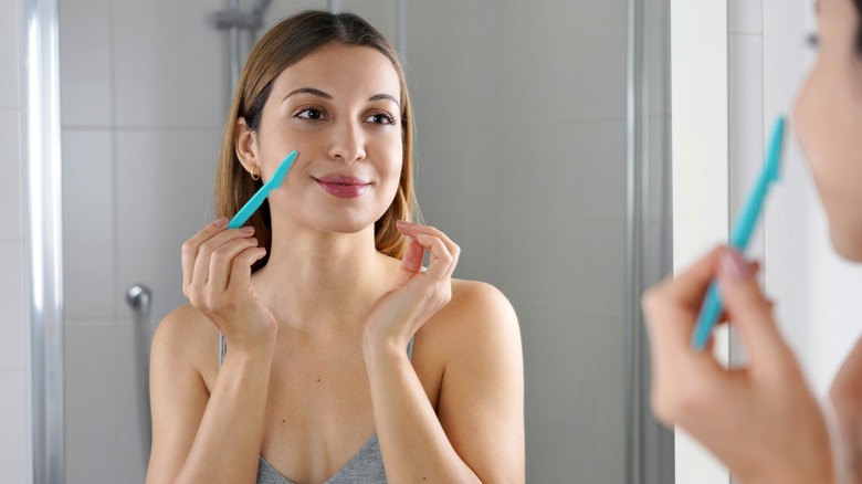 woman doing dermaplaning at home 