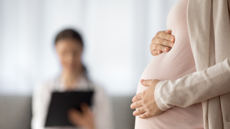 Pregnant woman holding vitamin