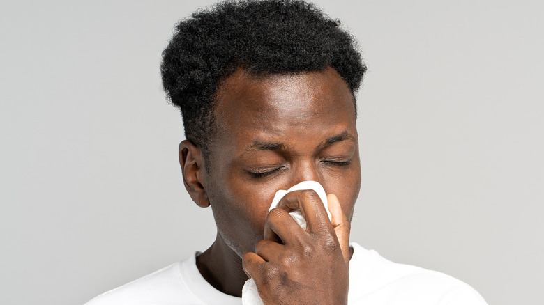 man blowing his nose