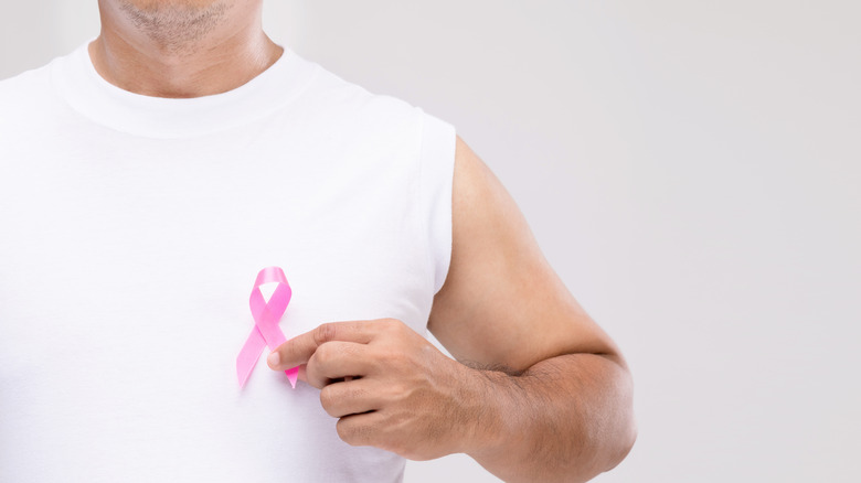 Man holding pink breast cancer ribbon