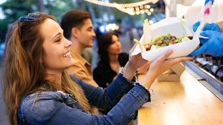 Woman buying street food while on a trip