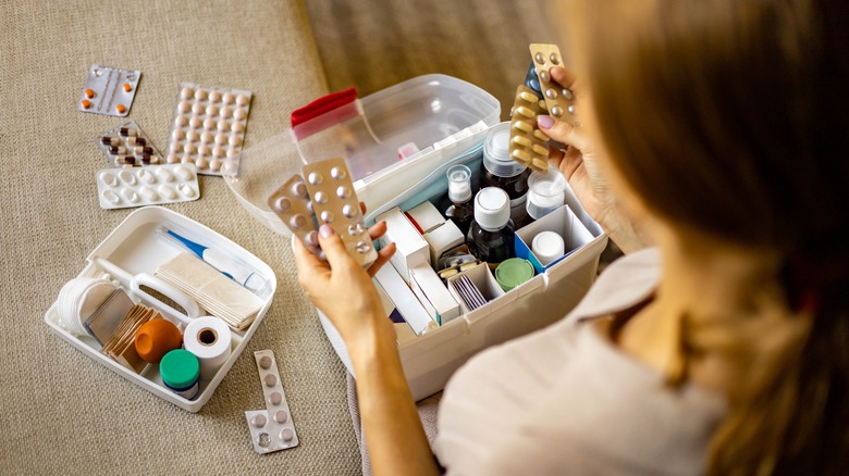 Woman looking through first aid kit