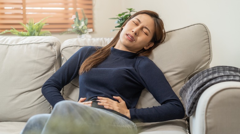 woman holding her stomach in pain