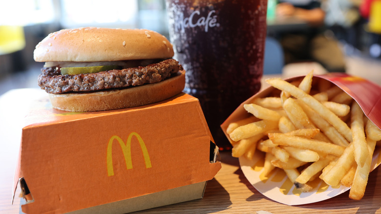 A McDonald's quarter pounder on top of its box with a side of fries