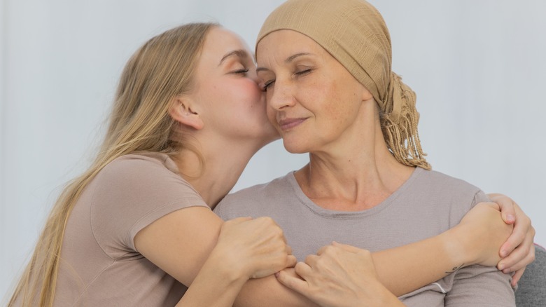 young daughter kissing mother's cheek