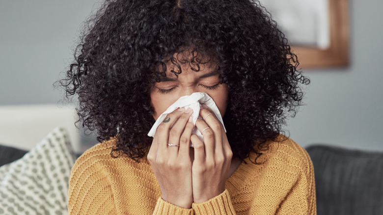 Woman with a cold blowing her nose