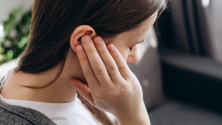 A woman holding her painful ear