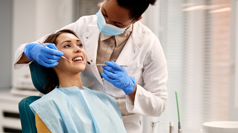 Doctor examining teeth of female patient