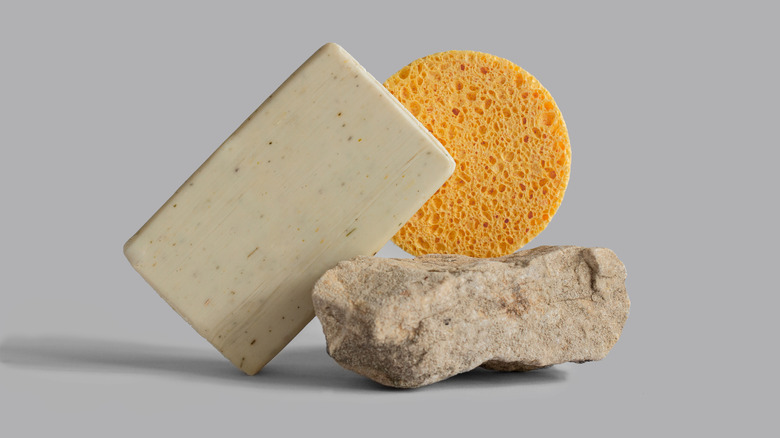 Sponge next to soap and rock