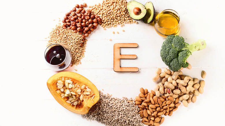 A selection of foods rich in vitamin e arranged in a circle around a letter E