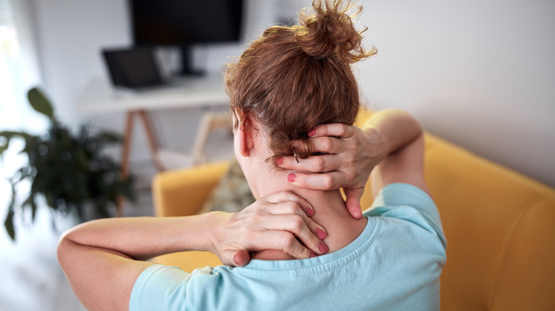 woman rubbing neck