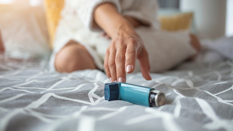 person reaching for inhaler