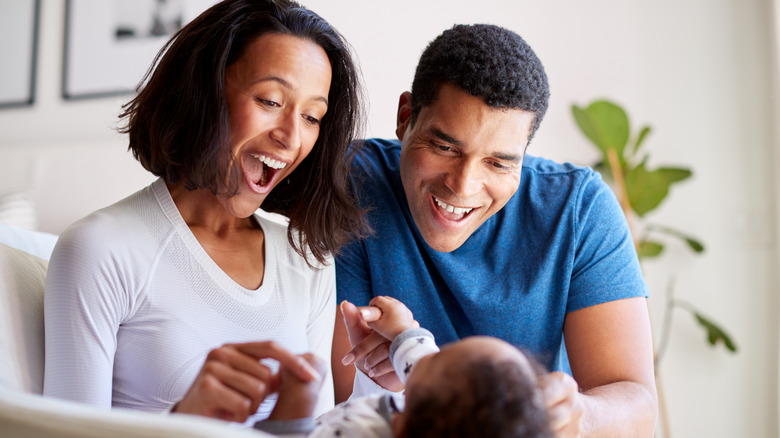 Parents smiling at baby on mom's lap