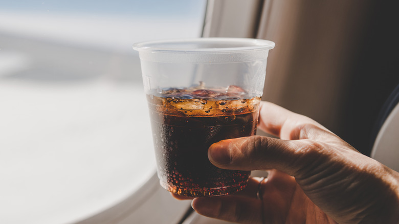 man on plane drinking Diet Coke