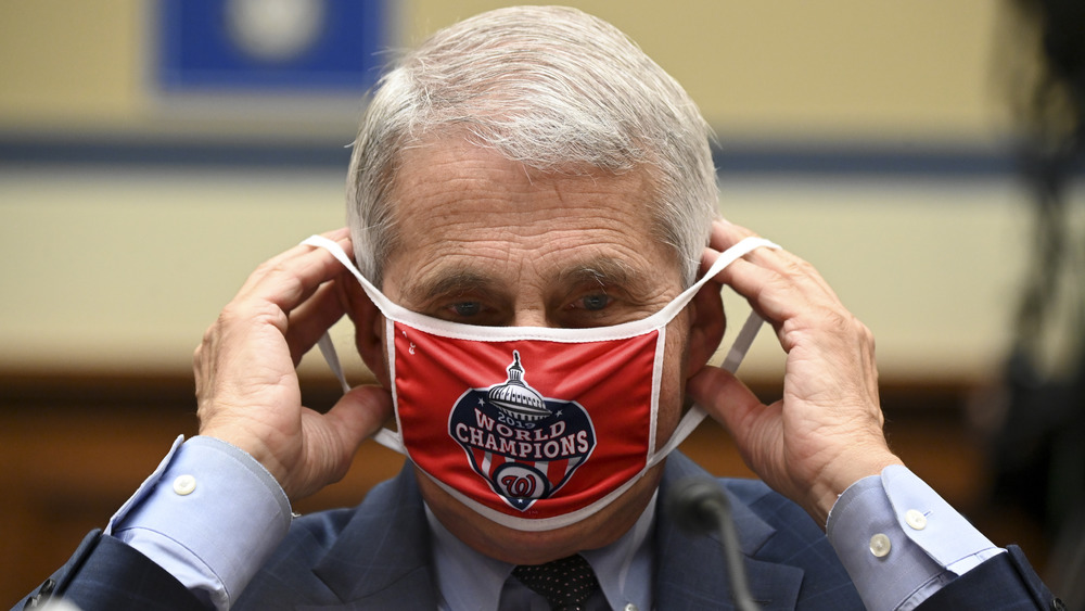 Dr. Anthony Fauci putting on Washington Nationals face mask