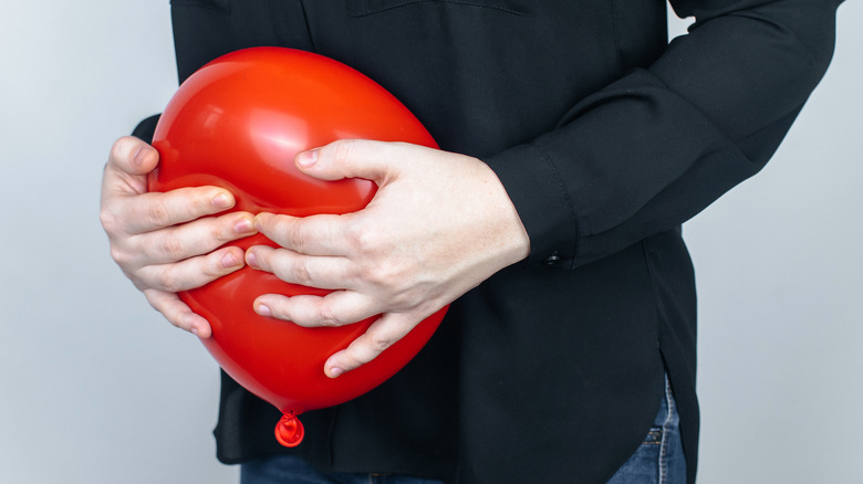 person holding balloon near abdomen