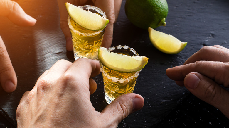 hands holding tequila shots