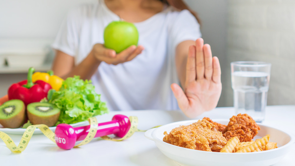 woman taking an apple instead of fried chicken