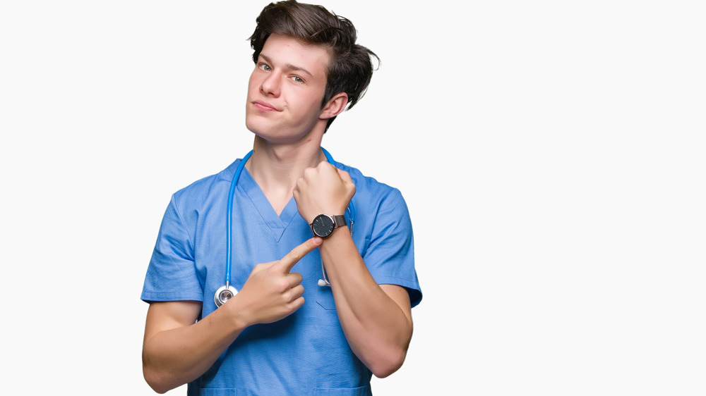 Doctor pointing at watch