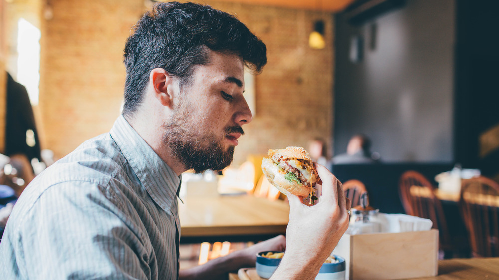 Man eating cheeseburger