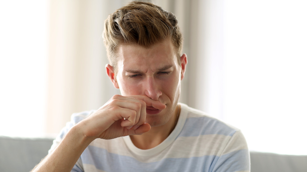 Man smelling finger