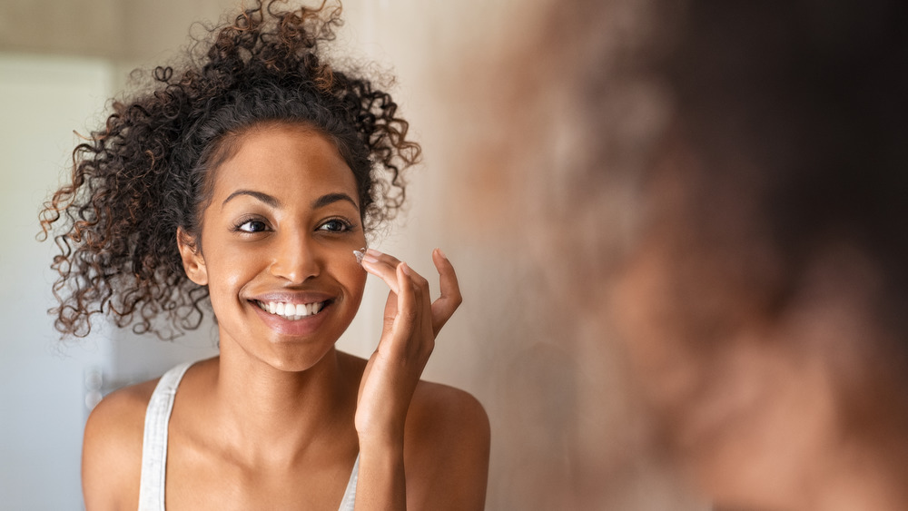 Woman moisturizing her face.