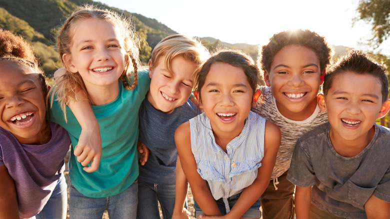 a diverse group of children smiling outside