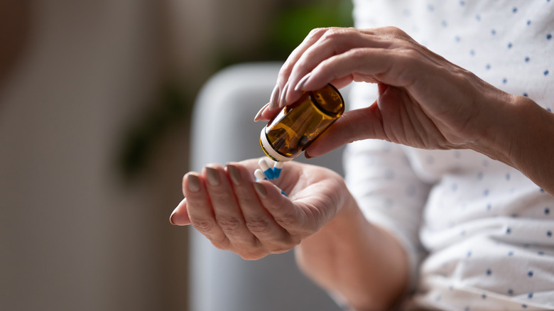 Woman shaking out pills from a bottle into her hand