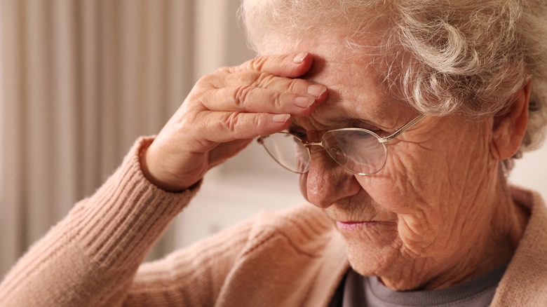 Senior woman holding her head in confusion