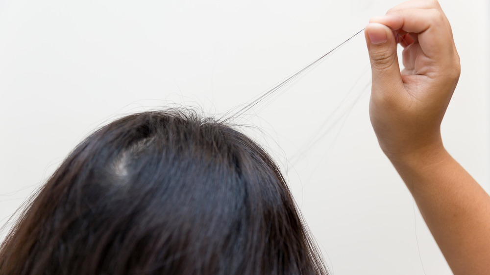 woman pulling a stand of hair 