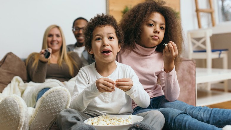 Family watching movie with popcorn