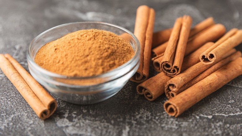 cinnamon sticks next to a glass jar of cinnamon