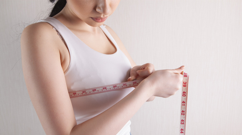 woman measuring her bra size