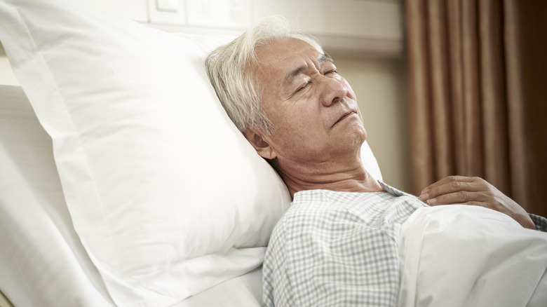 Sleeping older man in hospital bed