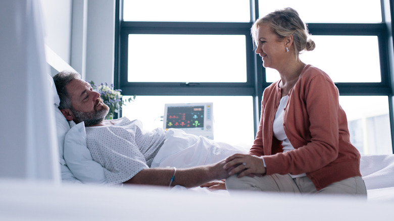 Couple looking at one another in hospital bed