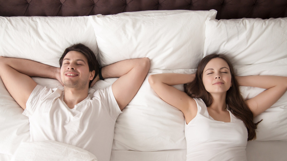 Couple lying in bed happy