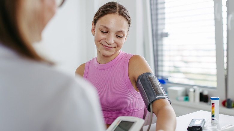 young woman having her blood pressure checked