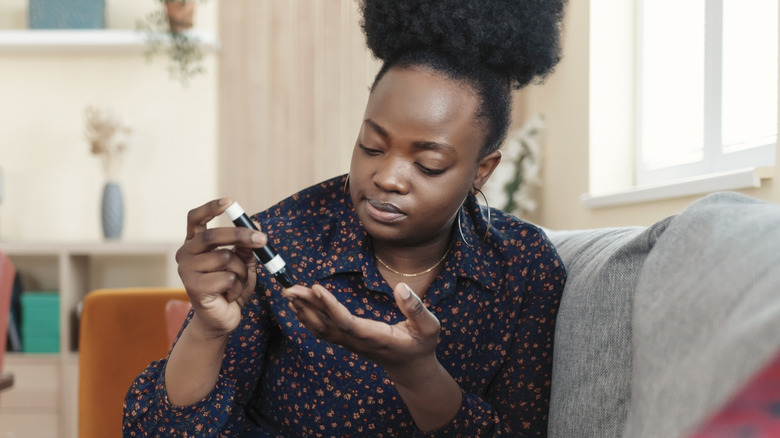 A woman pricking her finger testing blood sugar