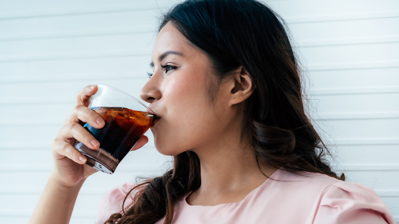 Woman drinking glass of soda