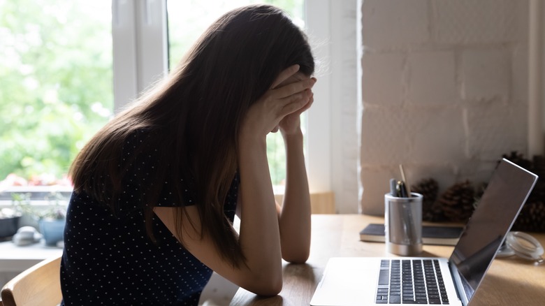 Woman sitting at computer in a bad mood 