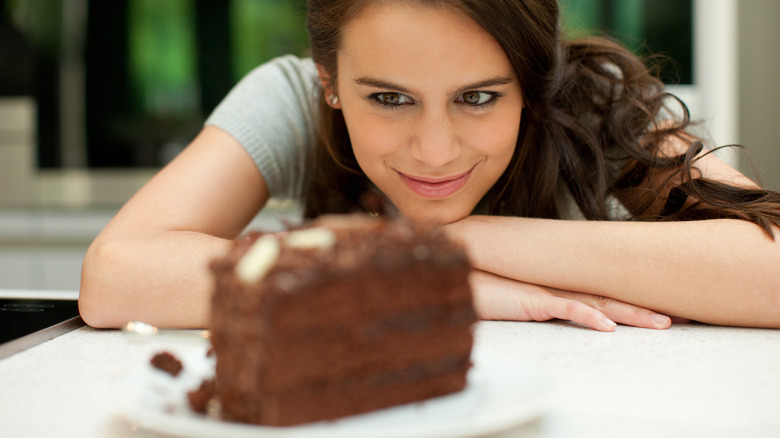 Woman hungrily looking at chocolate cake