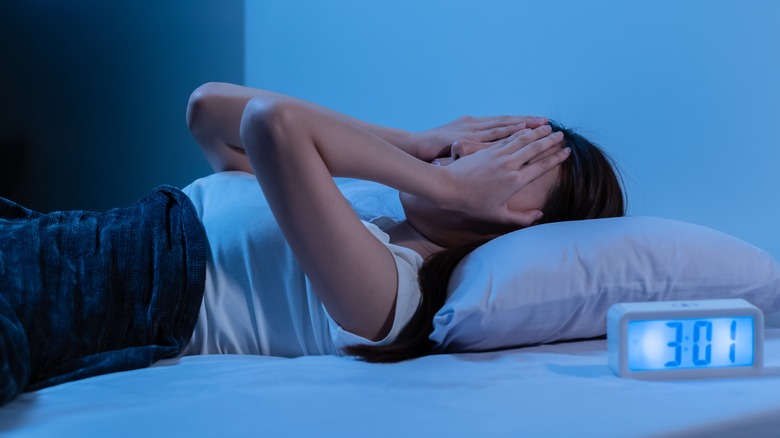 Stressed woman lying in bed