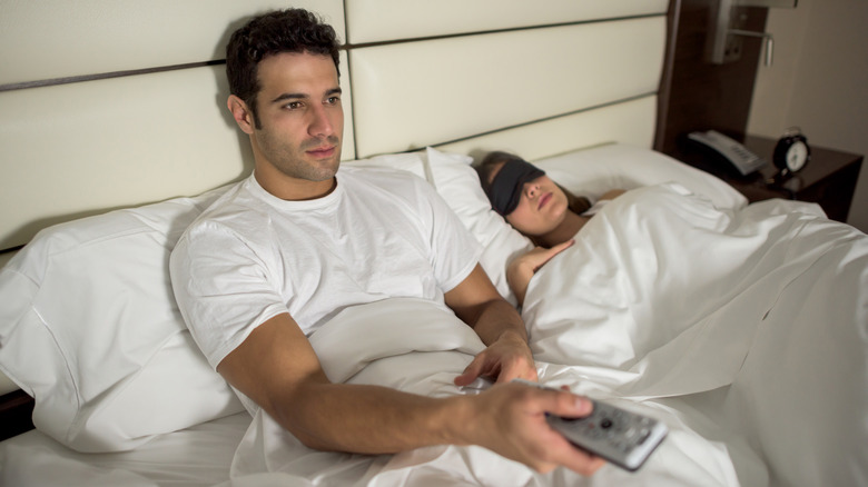 Man in bed with TV on unable to sleep